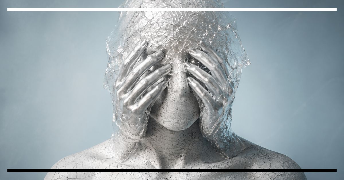 Figura humana coberta de tinta prateada rachada e plástico transparente, com mãos cobrindo o rosto, sugerindo os limites da inteligência artificial como imitação do humano.