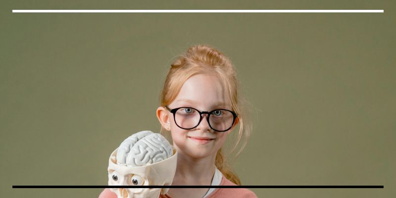 Imagem de uma menina segurando um esqueleto humano.