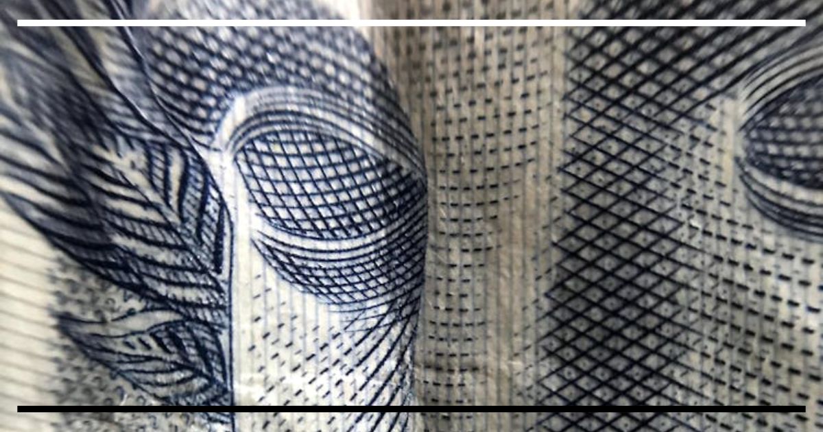 Close em detalhe de cédula do real, destacando traços do rosto e microimpressões, remetendo a câmbio e conta corrente.