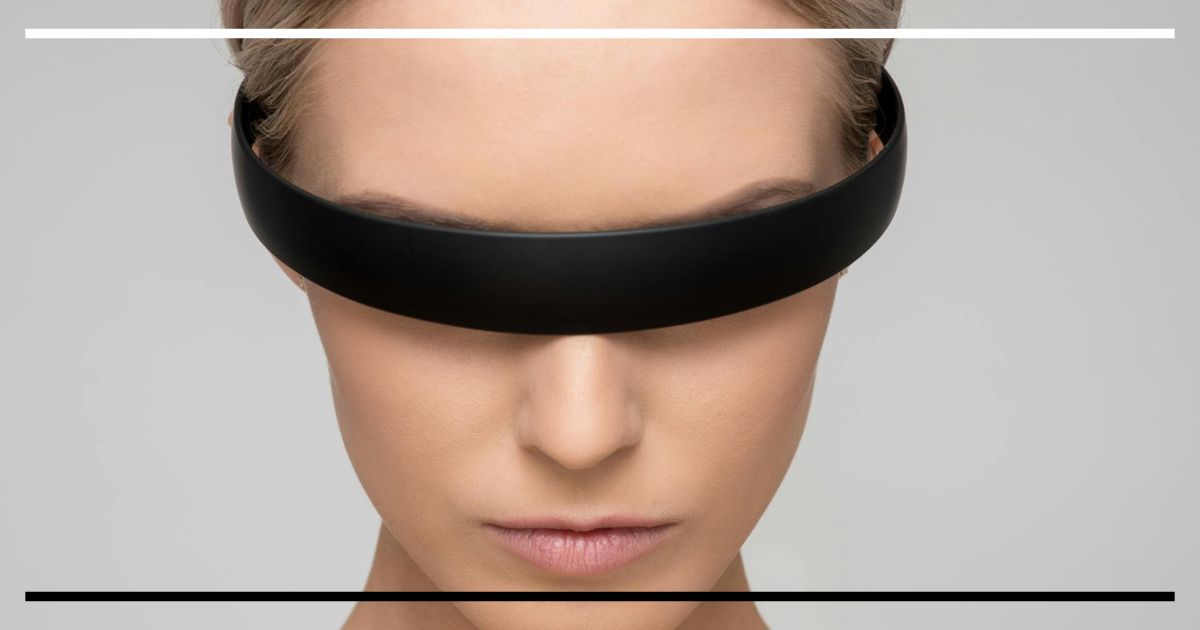 Pessoa com viseira tecnológica cobrindo os olhos, simbolizando a fusão entre corpo e tecnologia.