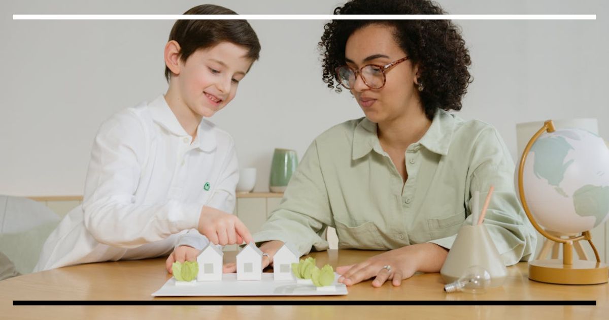 Professora e criança observando um modelo de casas sobre a mesa, explorando ideias e fazendo perguntas em um ambiente de aprendizado ativo.