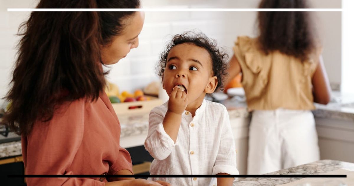 Mãe e criança interagem durante um lanche na cozinha, representando rotina previsível e vínculo afetivo no cotidiano infantil.