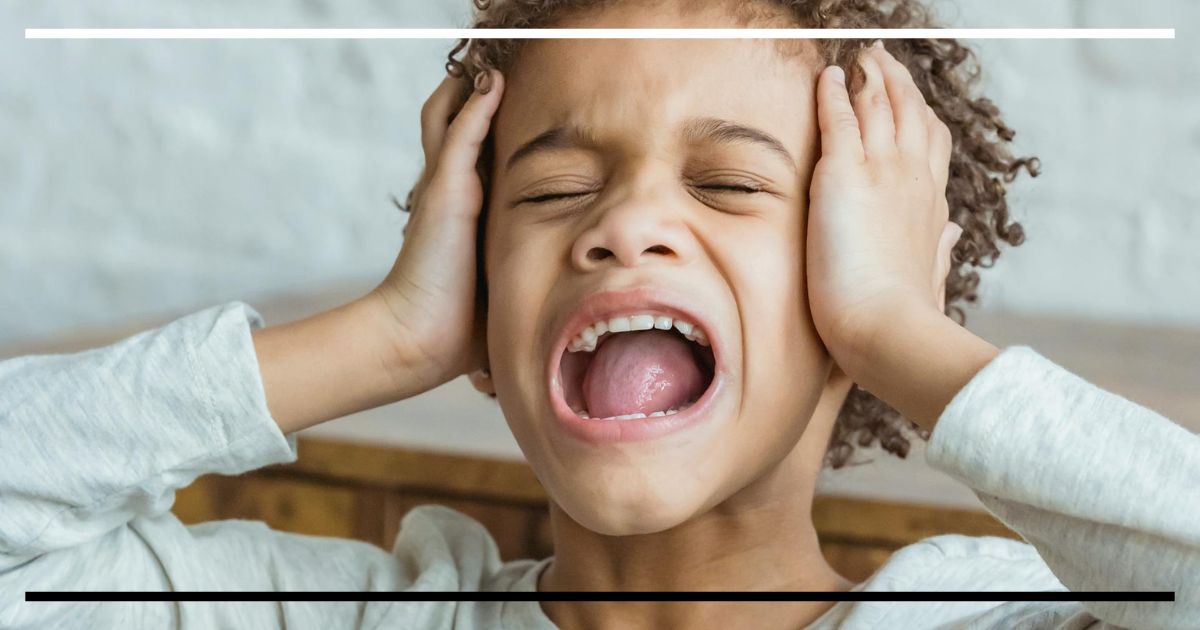 Criança com expressão de sobrecarga emocional, ilustrando o controle inibitório infantil em desenvolvimento.